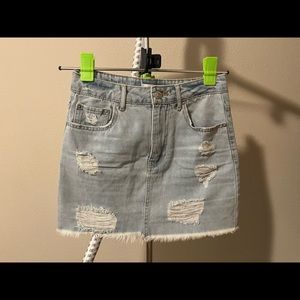 A light denim mini skirt featuring a mid-rise waist, and back zipper.